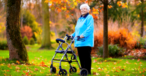 elderly woman walking with four wheeled walker in woods
