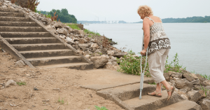 Woman using underarm crutches to get up outdoor steps non weight bearing