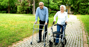 Woman and man, both with walkers, walking outdoors